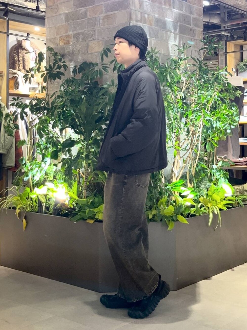 ブラック系のダウンジャケット/コート、グレー系のデニムパンツ、ブラック系のニット/セーターを着用したメンズの冬コーディネートの3枚目の写真