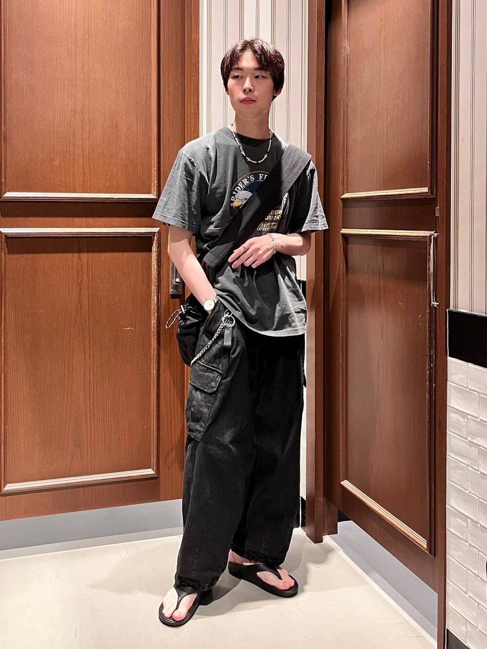 ブラック系のサンダル、グレー系のデニムパンツ、ブラック系のショルダーバッグを着用したメンズの夏コーディネートの4枚目の写真