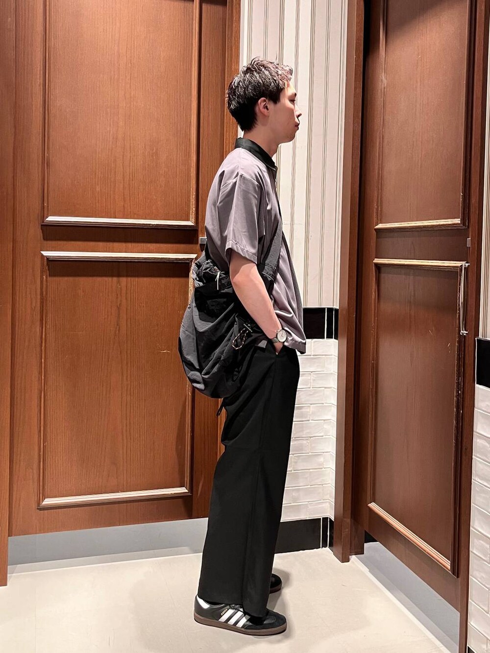 ブラック系のスラックス、ブラック系のショルダーバッグ、グレー系のシャツ/ブラウスを着用したメンズの夏コーディネートの5枚目の写真