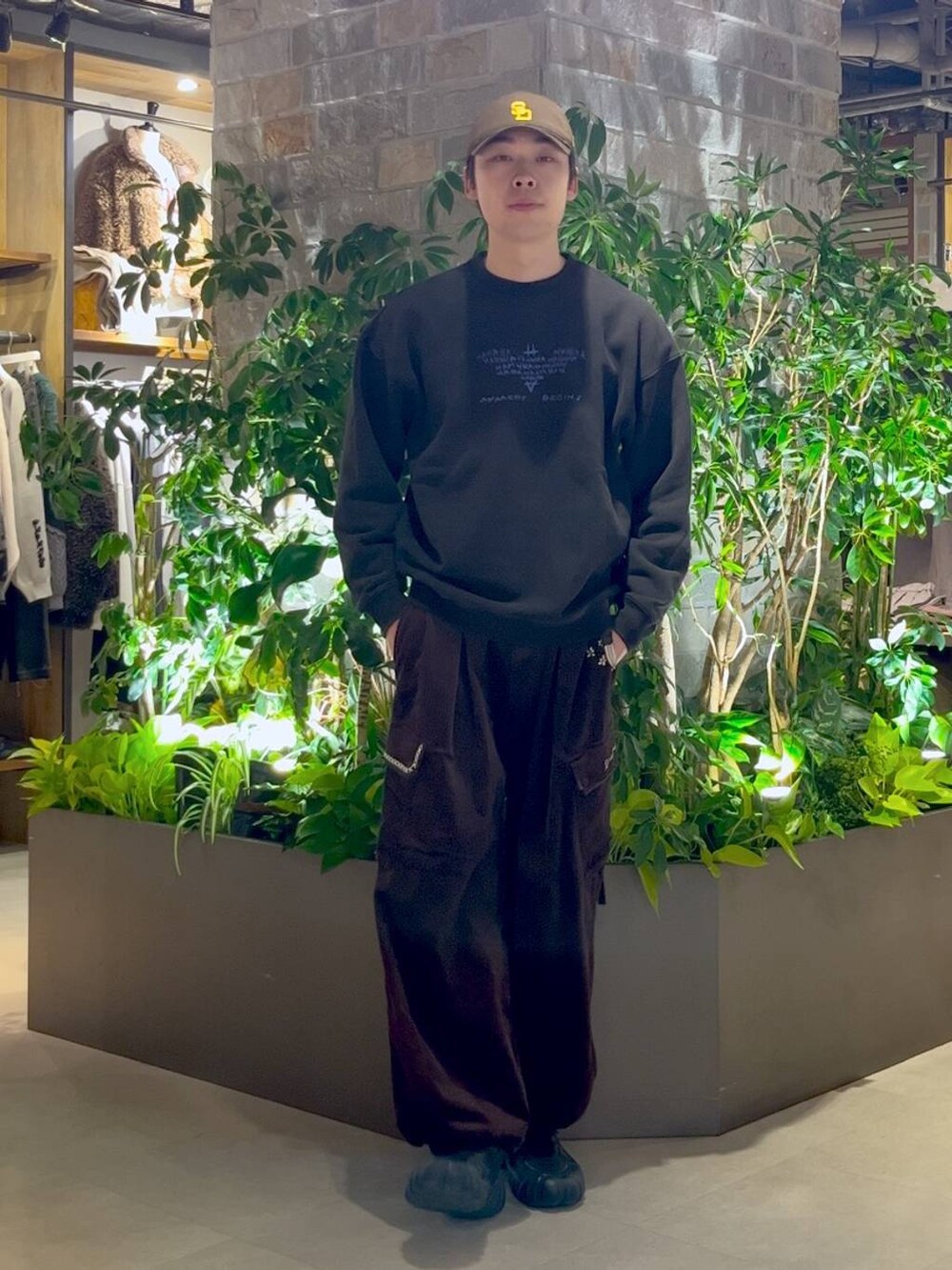 ブラウン系のカーゴパンツ、ブラック系のスウェット、ブラウン系のキャップを着用したメンズの冬コーディネートの4枚目の写真