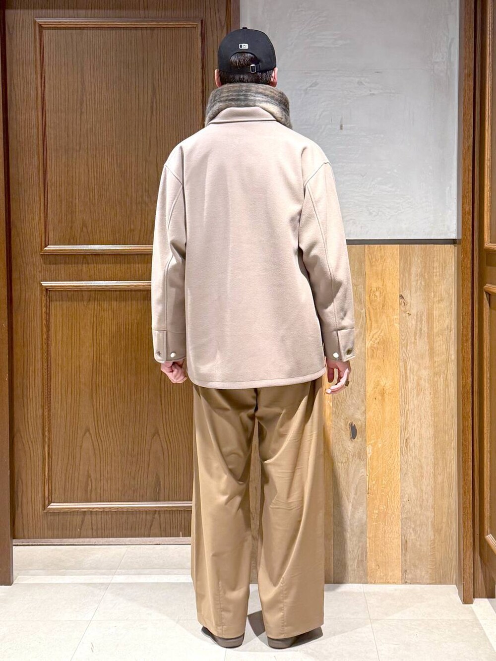 ホワイト系のニット/セーター、ベージュ系のブルゾン、ベージュ系のスラックスを着用したメンズの冬コーディネートの4枚目の写真
