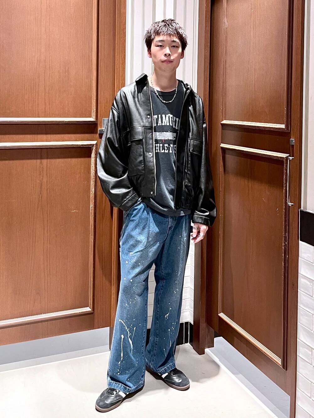 ブラック系のブルゾン、ブルー系のデニムパンツを着用したメンズの夏コーディネートの2枚目の写真