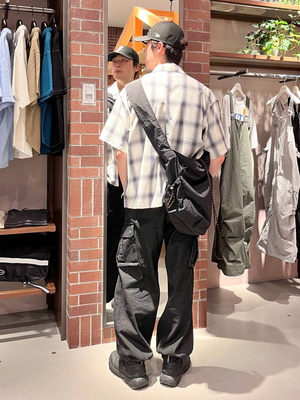 グレー系のデニムパンツ、ブラック系のショルダーバッグ、ブルー系のシャツ/ブラウスを着用したメンズの夏コーディネートの5枚目の写真