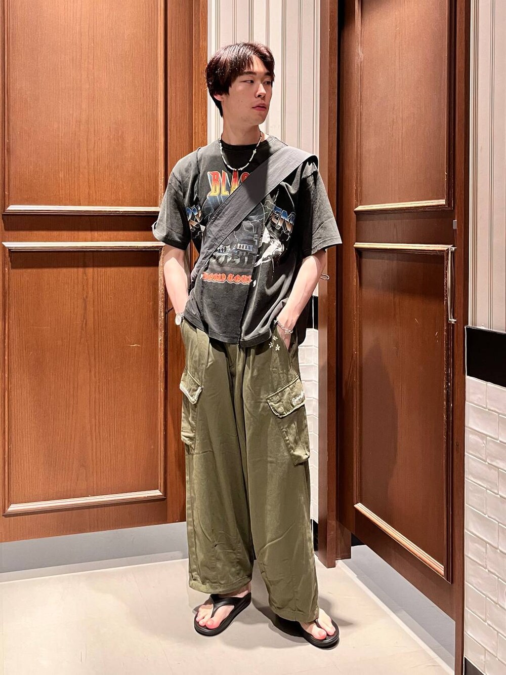 ブラック系のサンダル、グリーン系のカーゴパンツ、グレー系のショルダーバッグを着用したメンズの夏コーディネートの6枚目の写真