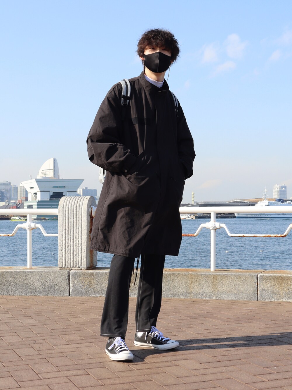 ブラック系のモッズコート、ブラック系のその他パンツ、ホワイト系のTシャツ/カットソーを着用したメンズの冬コーディネートの2枚目の写真