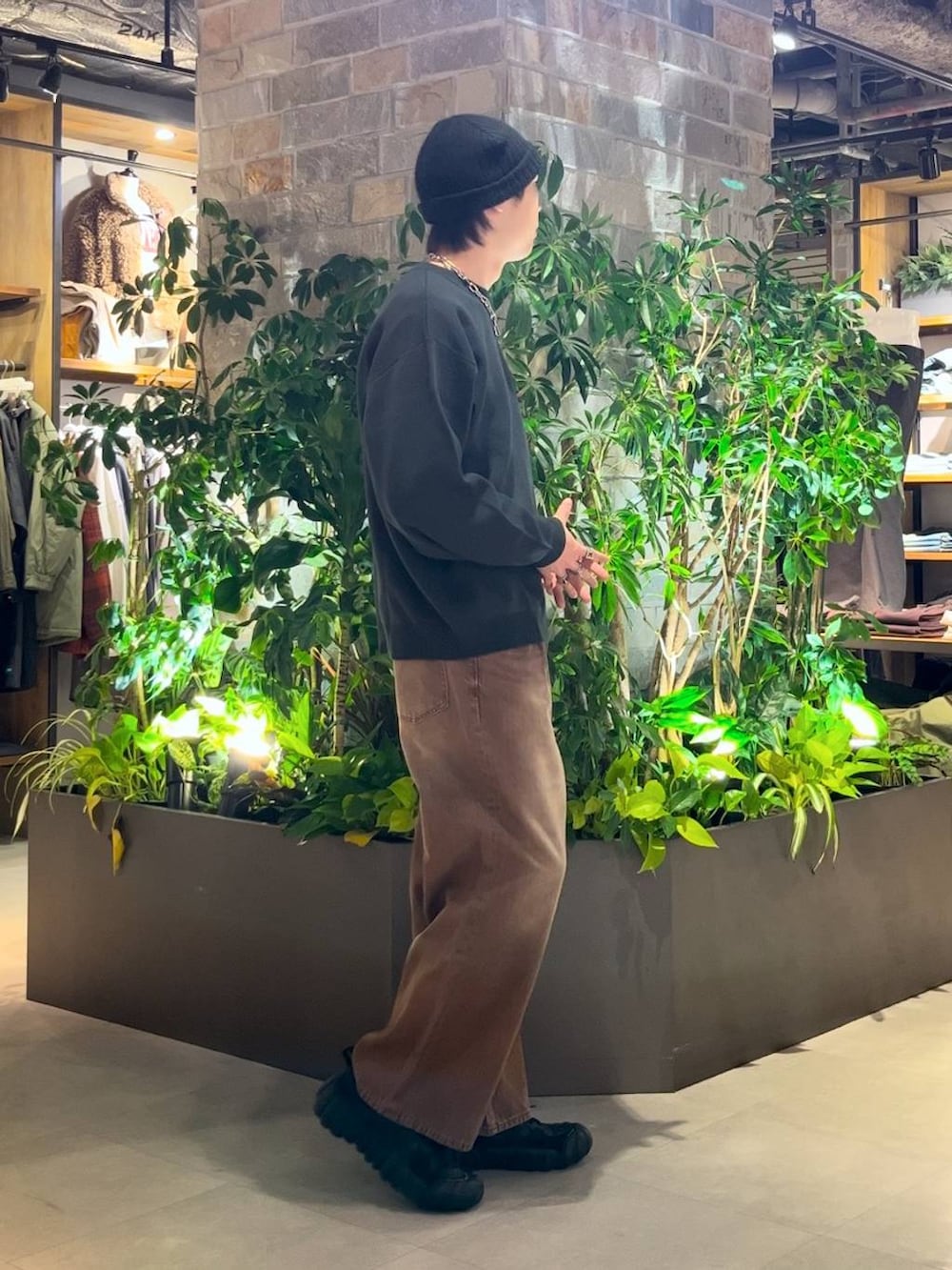 ブラウン系のデニムパンツ、グリーン系のニット/セーターを着用したメンズの冬コーディネートの5枚目の写真