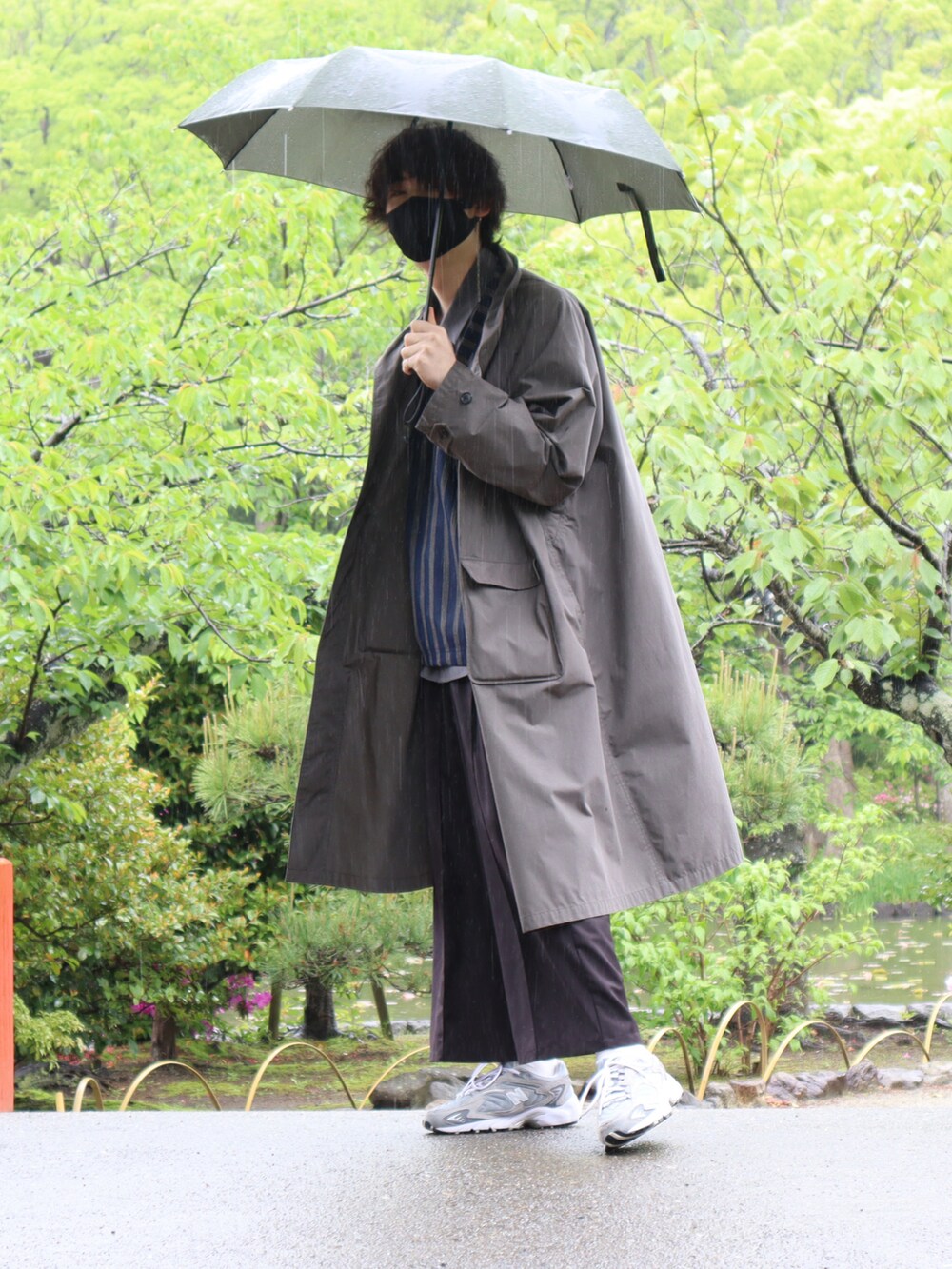 グレー系のトレンチコート、ブルー系のベスト、グレー系のシャツ/ブラウスを着用したメンズの春コーディネートの2枚目の写真