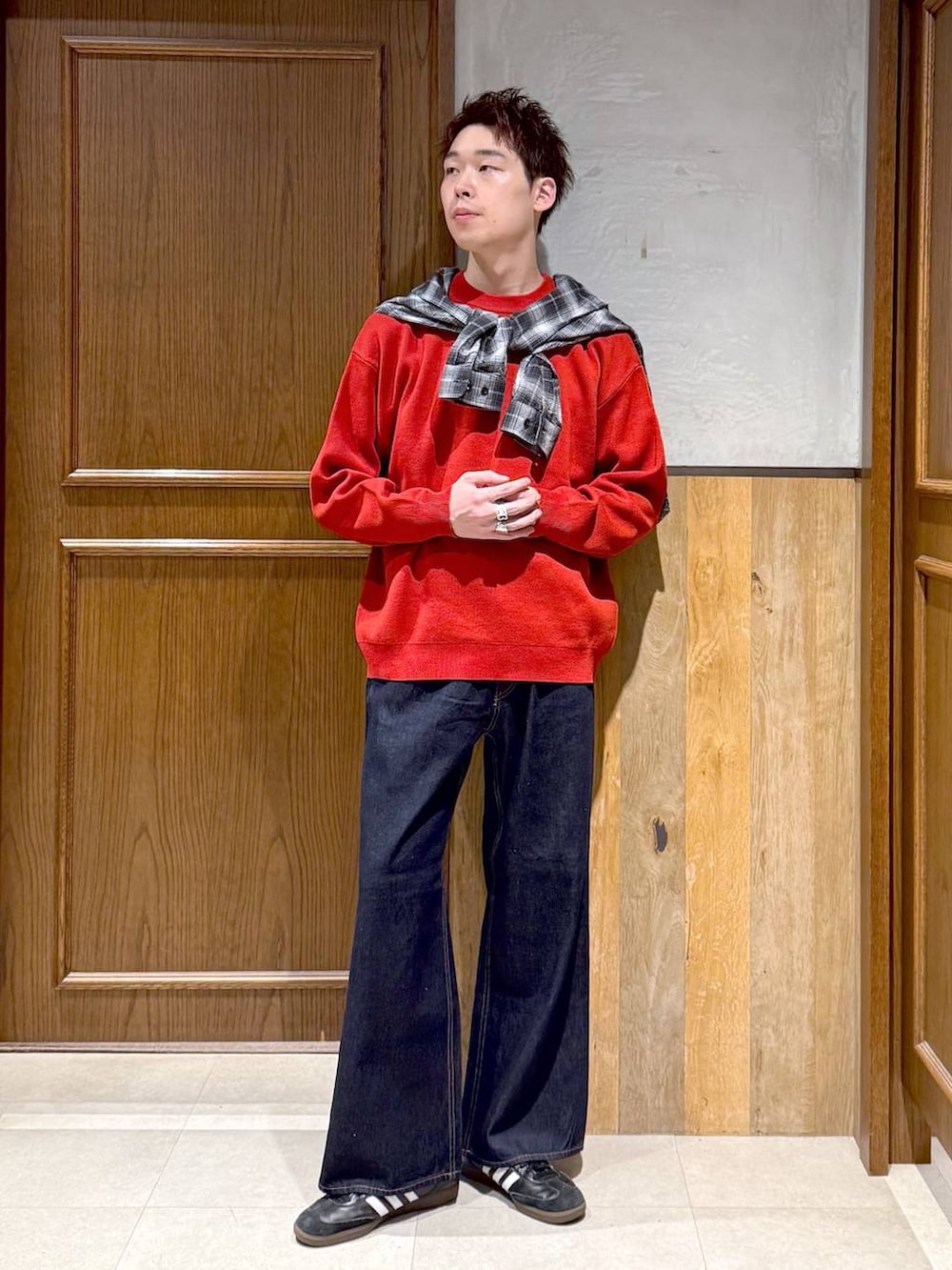 ブラック系のシャツ/ブラウス、ブルー系のデニムパンツ、レッド系のニット/セーターを着用したメンズの秋コーディネートの6枚目の写真