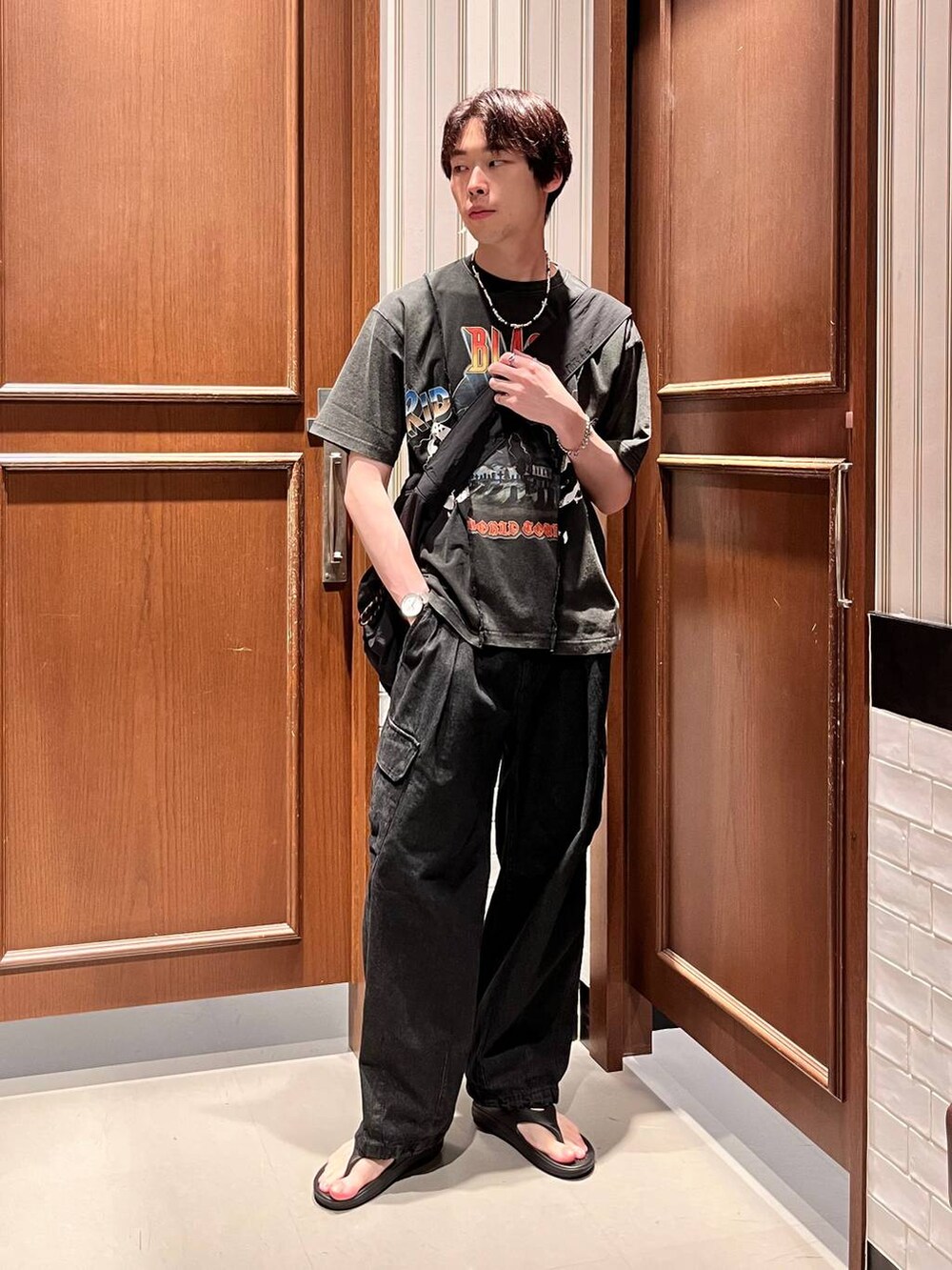 グレー系のデニムパンツ、ブラック系のショルダーバッグ、ブラック系のサンダルを着用したメンズの夏コーディネートの2枚目の写真