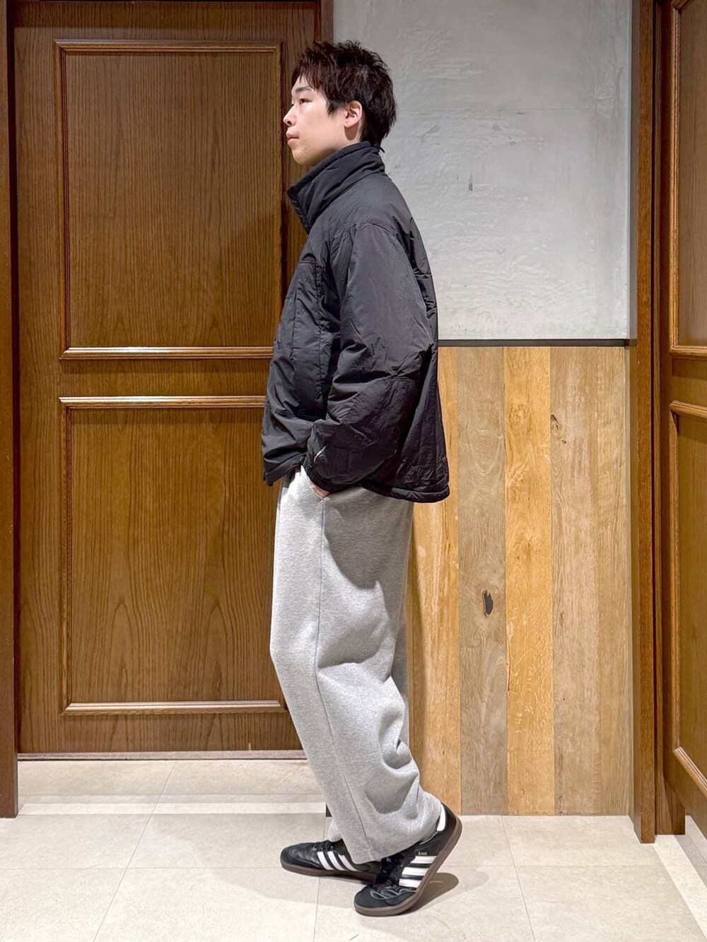 ブラック系のダウンジャケット/コート、ブルー系のニット/セーター、グレー系のスウェットパンツを着用したメンズの冬コーディネートの4枚目の写真