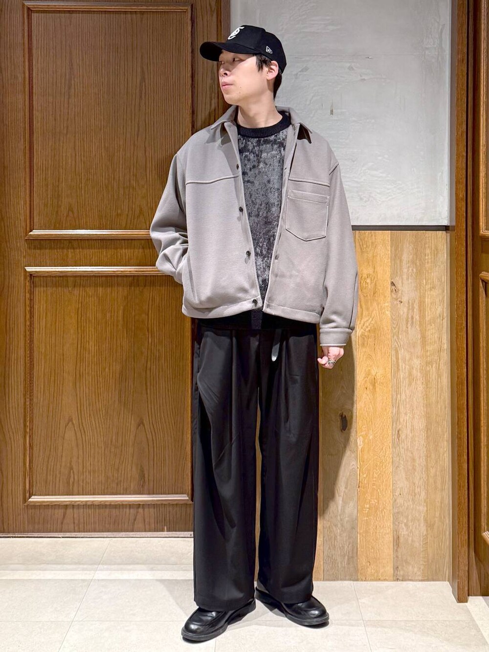 ベージュ系のブルゾン、ブラック系のニット/セーター、ブラック系のスラックスを着用したメンズの冬コーディネートの2枚目の写真