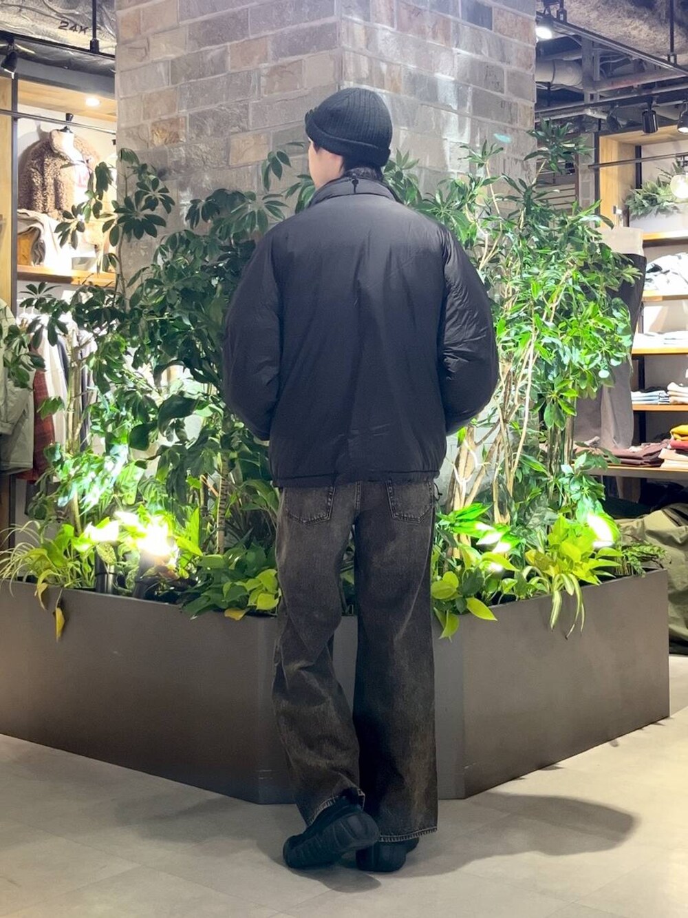 ブラック系のダウンジャケット/コート、グレー系のデニムパンツ、ブラック系のニット/セーターを着用したメンズの冬コーディネートの4枚目の写真