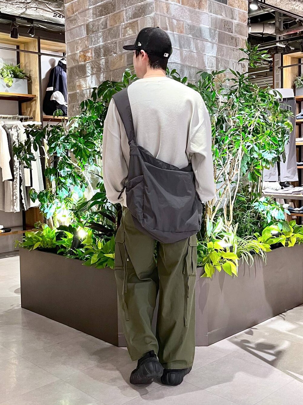 グリーン系のカーゴパンツ、その他のショルダーバッグ、ホワイト系のニット/セーターを着用したメンズの春コーディネートの4枚目の写真