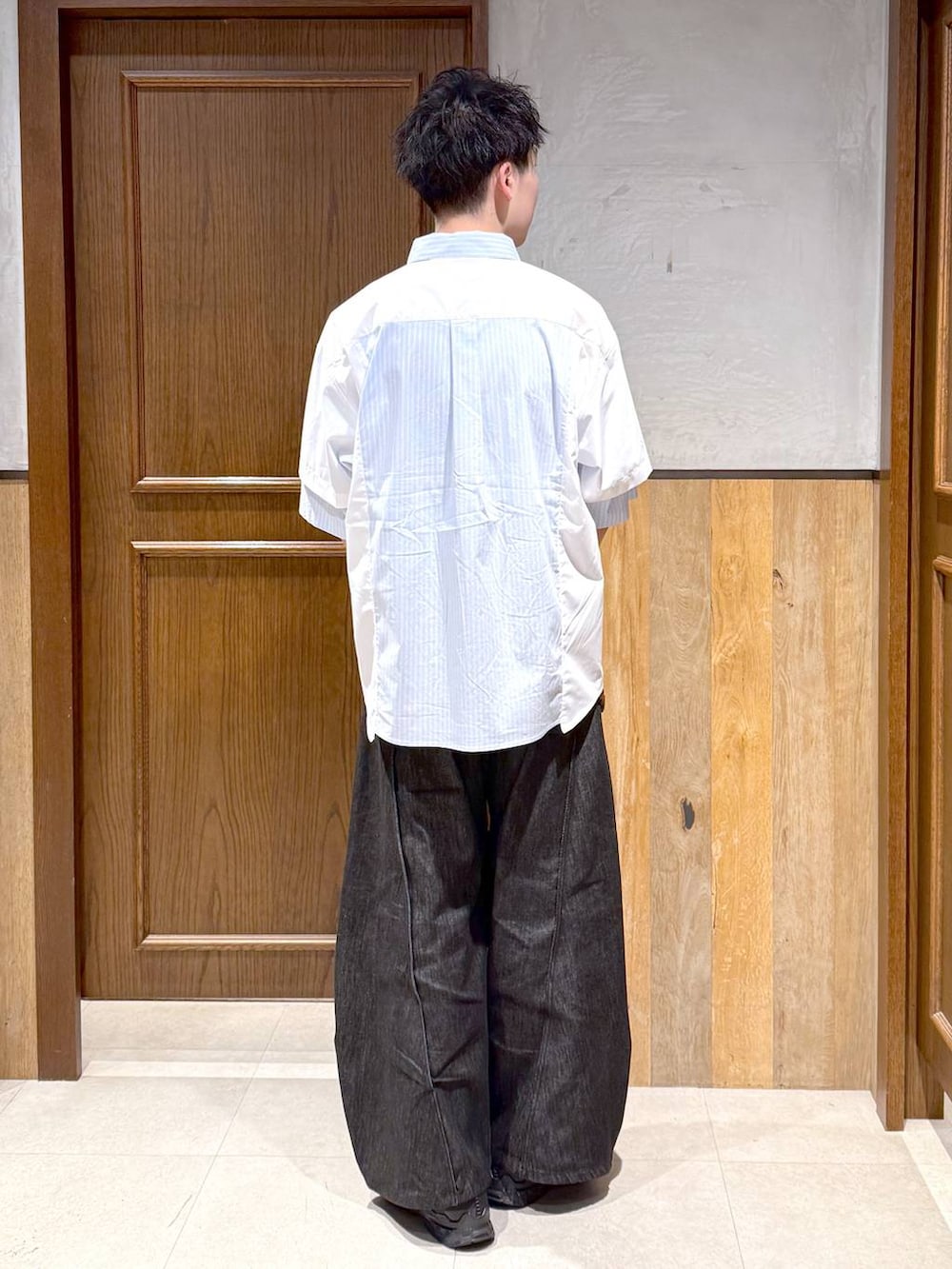 ブラック系のトートバッグ、ブラック系のデニムパンツ、ホワイト系のシャツ/ブラウスを着用したメンズの春コーディネートの4枚目の写真