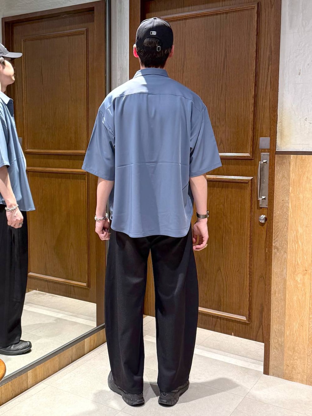 ブルー系のシャツ/ブラウス、ホワイト系のTシャツ/カットソー、ブラック系のスラックスを着用したメンズの春コーディネートの4枚目の写真