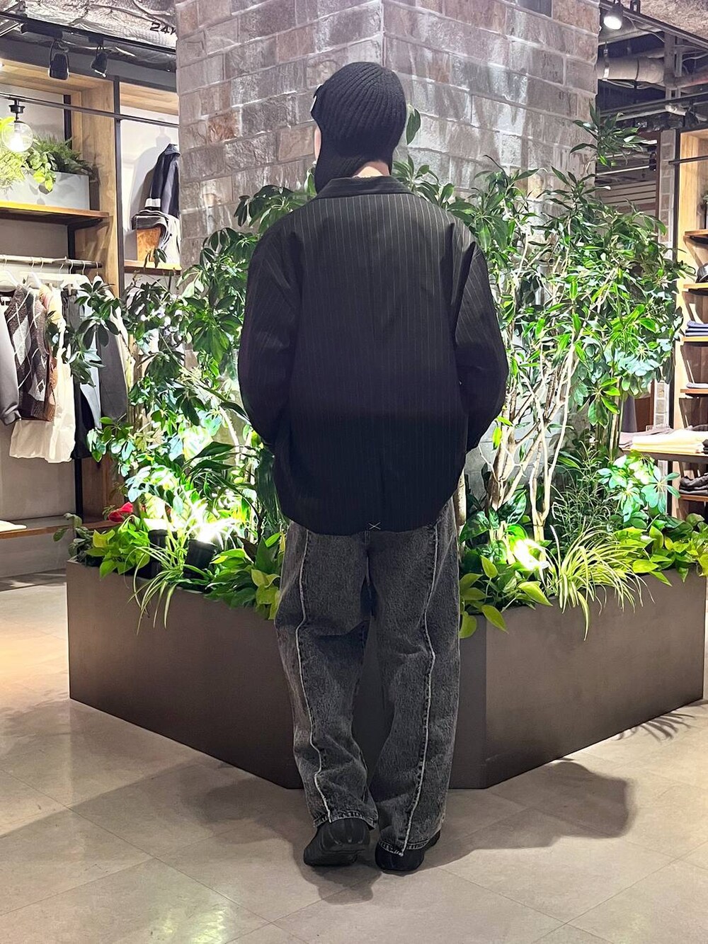 ブラック系のテーラードジャケット、ブラック系のスウェット、グレー系のデニムパンツを着用したメンズの冬コーディネートの4枚目の写真