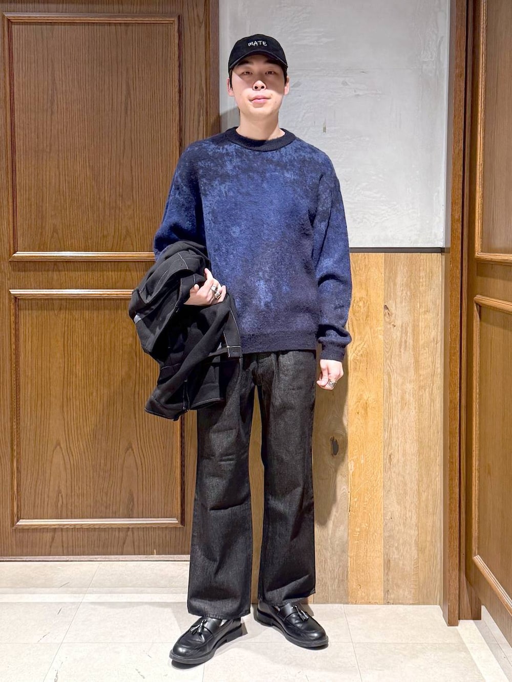 ブラック系のブルゾン、ブラック系のデニムパンツ、ブルー系のニット/セーターを着用したメンズの冬コーディネートの2枚目の写真