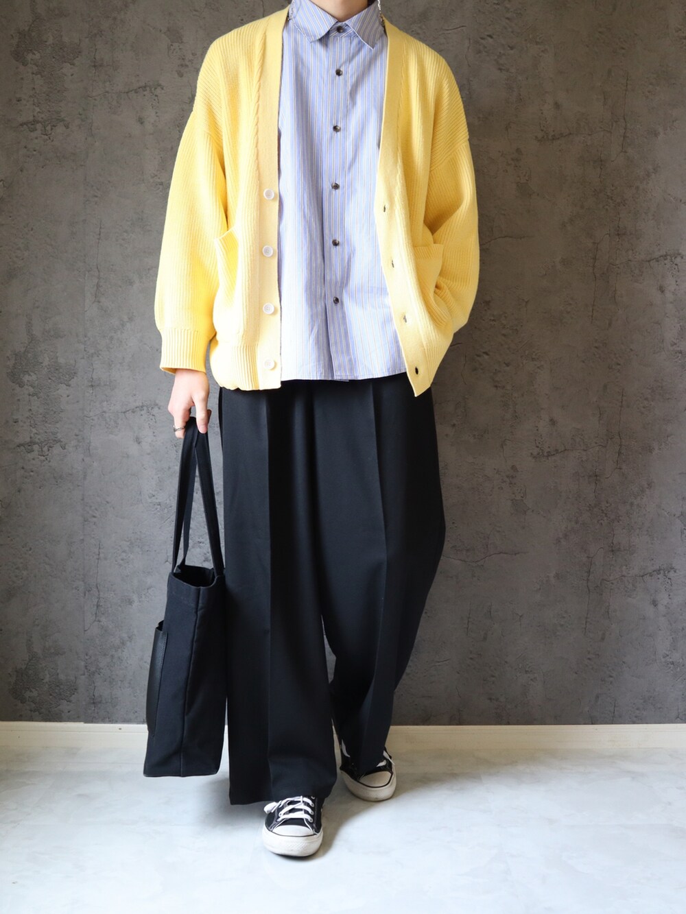 ブルー系のシャツ/ブラウス、イエロー系のニット/セーター、ブラック系のスラックスを着用したメンズの春コーディネートの2枚目の写真