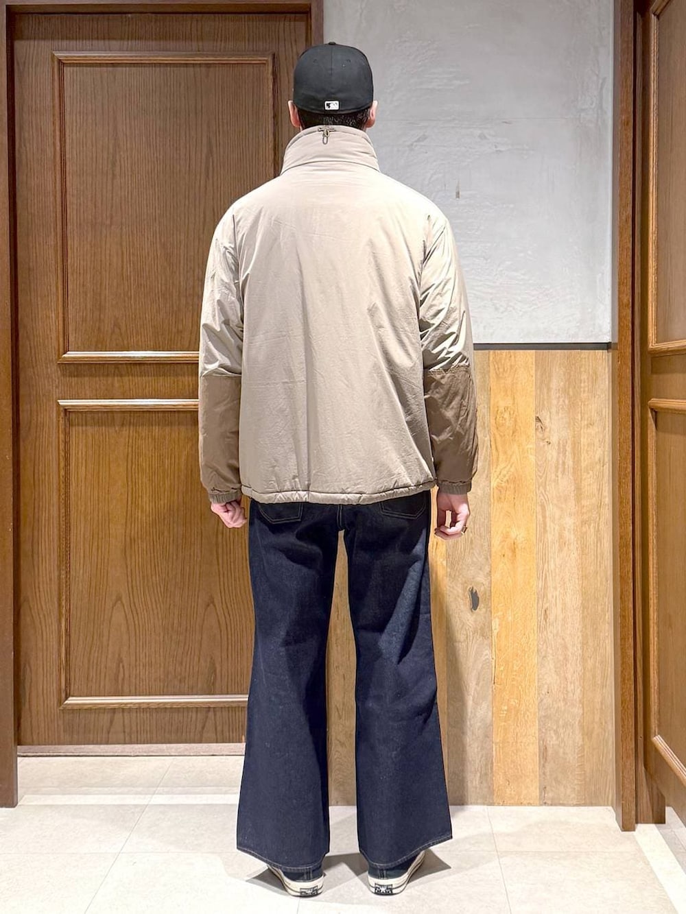 ブルー系のデニムパンツ、ブラウン系のダウンジャケット/コート、ブラウン系のニット/セーターを着用したメンズの冬コーディネートの6枚目の写真