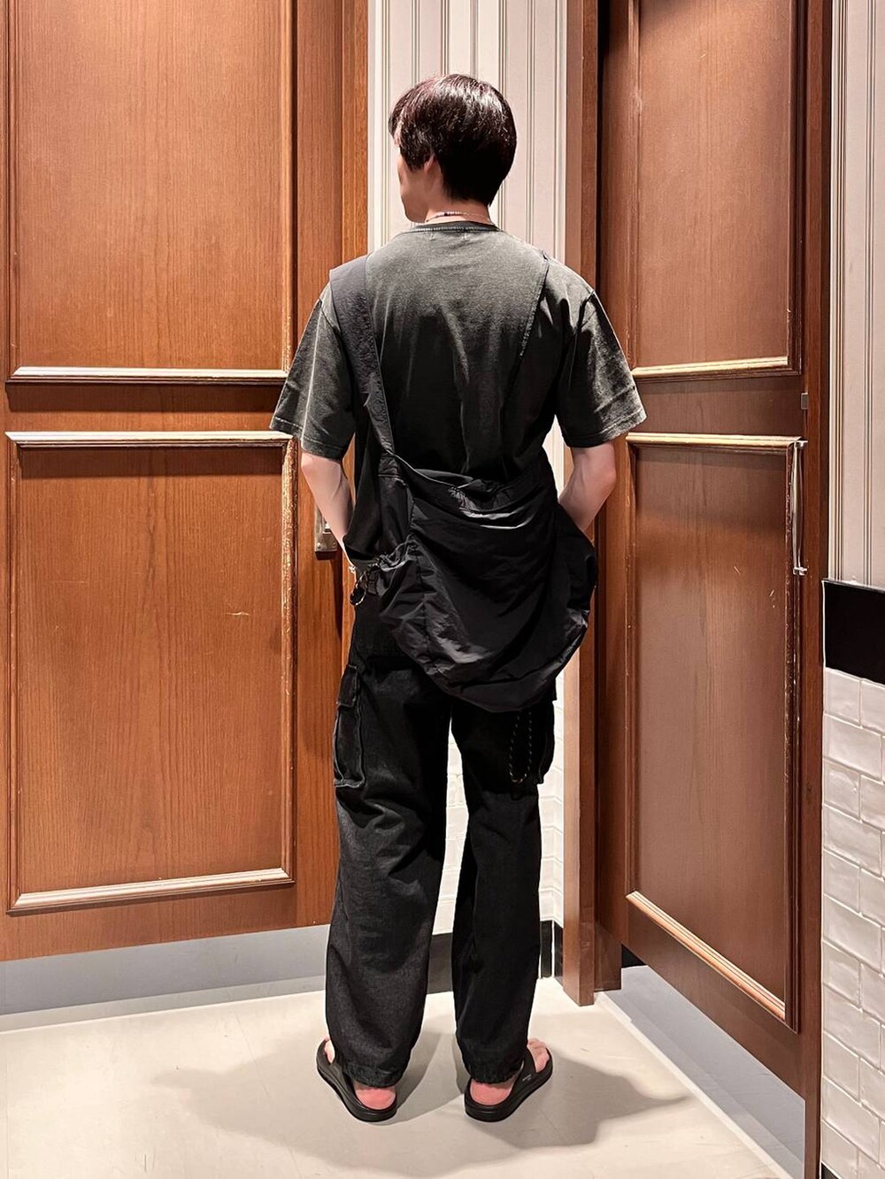 グレー系のデニムパンツ、ブラック系のショルダーバッグ、ブラック系のサンダルを着用したメンズの夏コーディネートの4枚目の写真