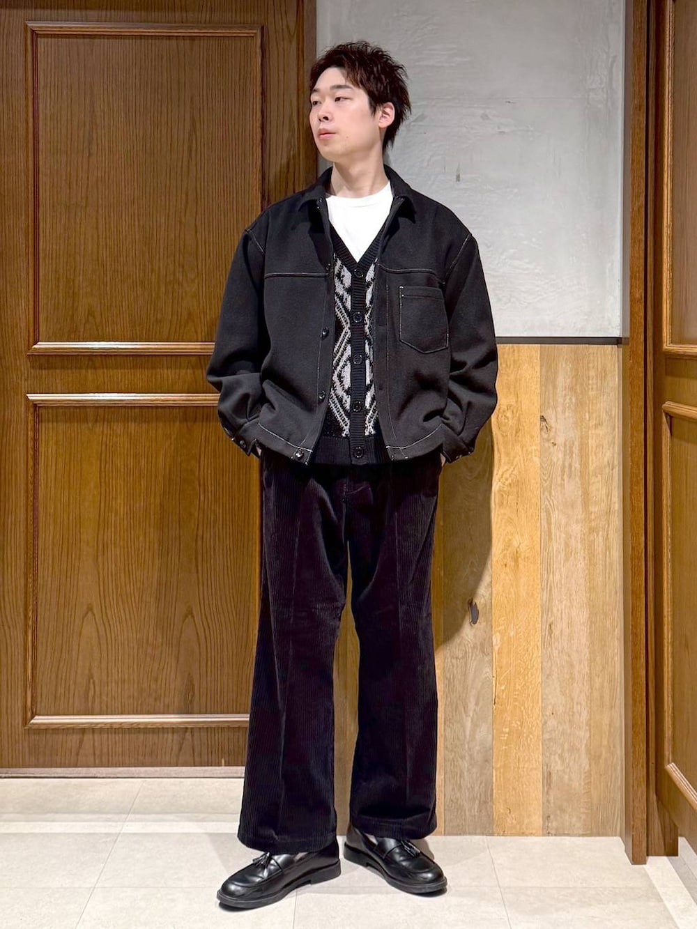 ブラック系のスラックス、ブラック系のブルゾン、ブラック系のカーディガン/ボレロを着用したメンズの秋コーディネートの3枚目の写真