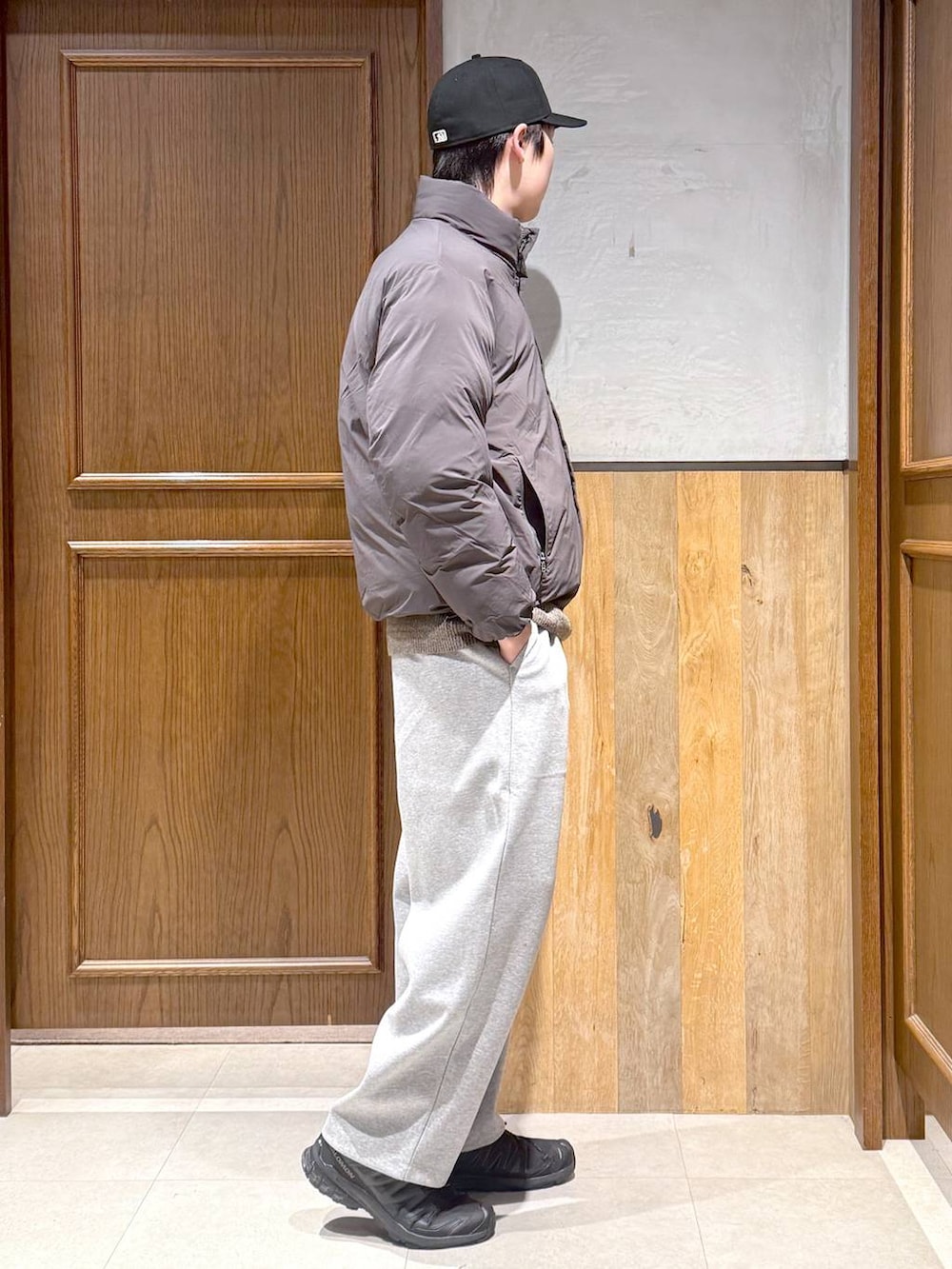 グレー系のダウンジャケット/コート、ベージュ系のポロシャツ、グレー系のスウェットパンツを着用したメンズの冬コーディネートの7枚目の写真