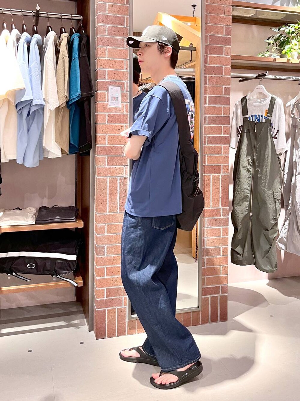 ブルー系のデニムパンツ、ブラック系のショルダーバッグ、ブルー系のTシャツ/カットソーを着用したメンズの夏コーディネートの4枚目の写真