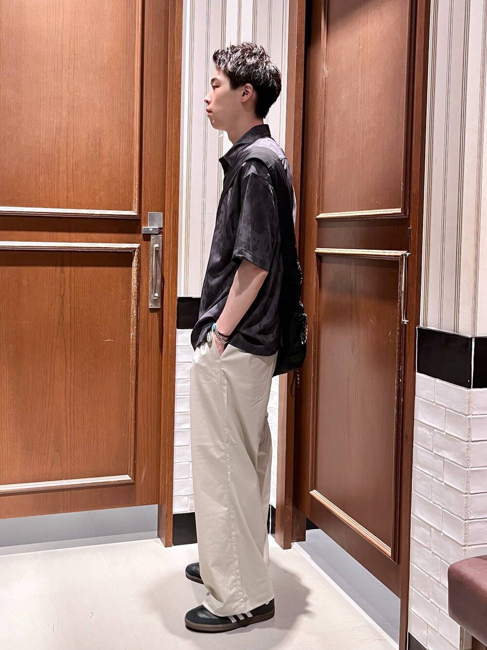 ホワイト系のスラックス、ブラック系のシャツ/ブラウス、ブラック系のショルダーバッグを着用したメンズの夏コーディネートの4枚目の写真