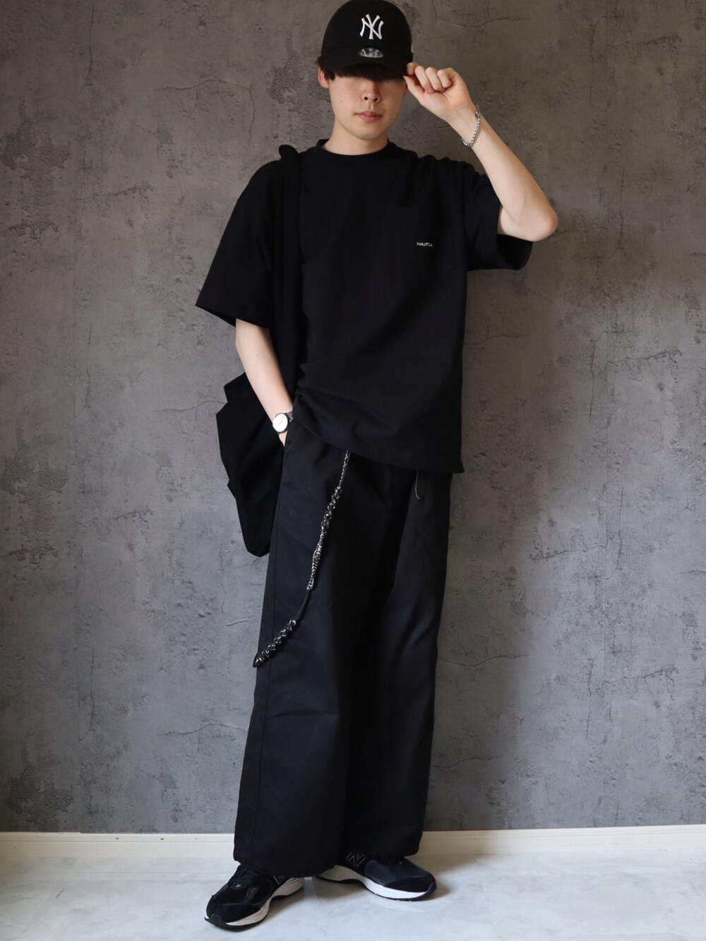 ブラック系のTシャツ/カットソー、ブラック系のチノパンツ、ブラック系のスニーカーを着用したメンズの春コーディネートの2枚目の写真