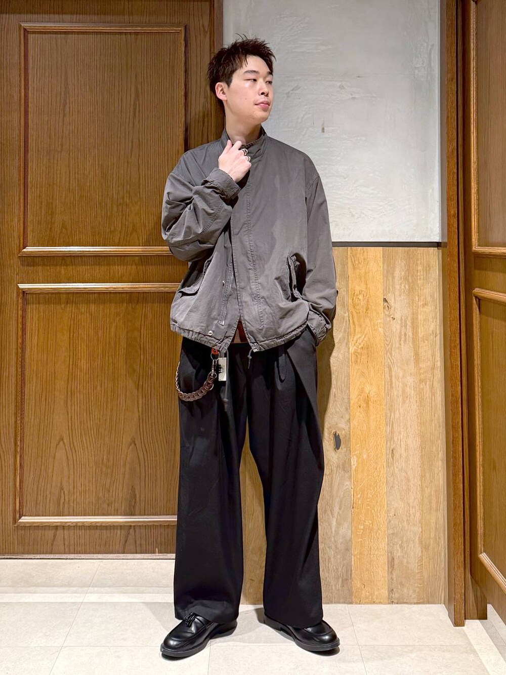 グレー系のモッズコート、ブラック系のスラックス、ブラウン系のスウェットを着用したメンズの秋コーディネートの7枚目の写真