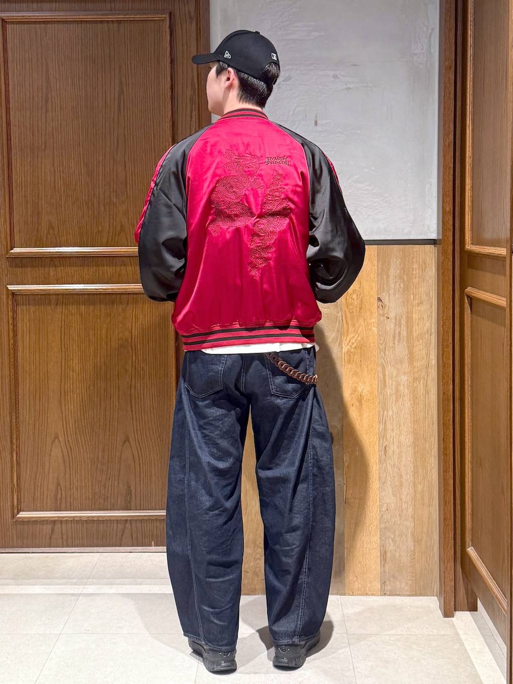 ホワイト系のTシャツ/カットソー、レッド系のスカジャン、ブルー系のデニムパンツを着用したメンズの春コーディネートの4枚目の写真