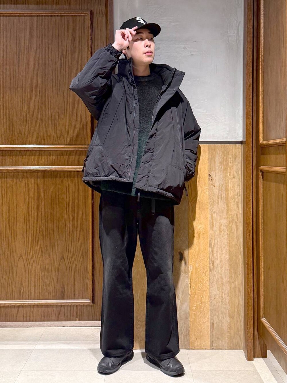 ブラック系のデニムパンツ、グリーン系のニット/セーター、ブラック系のダウンジャケット/コートを着用したメンズの冬コーディネートの3枚目の写真