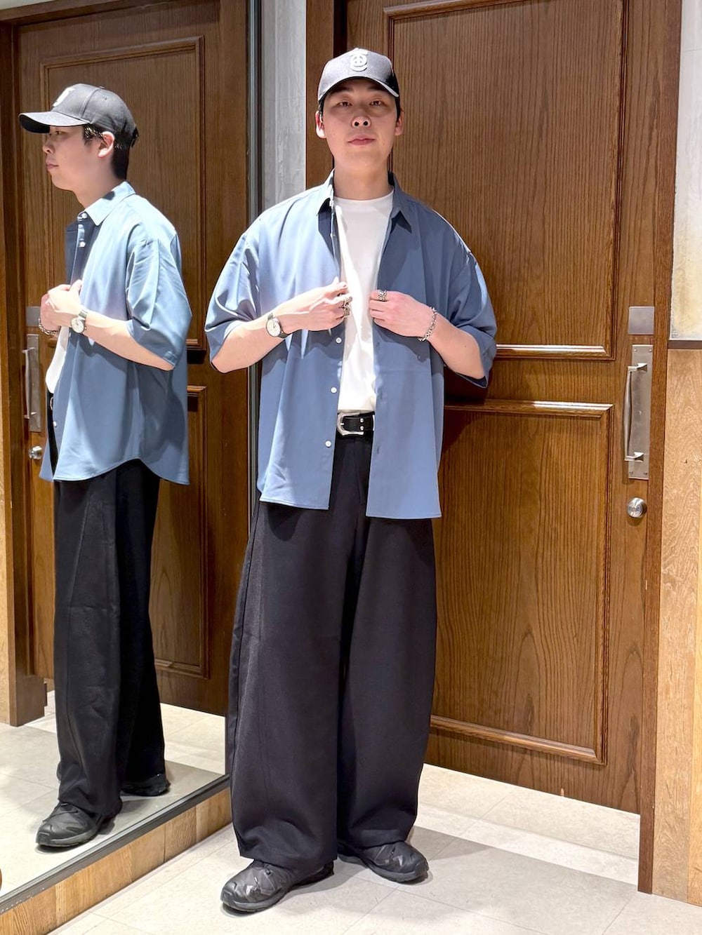 ブルー系のシャツ/ブラウス、ホワイト系のTシャツ/カットソー、ブラック系のスラックスを着用したメンズの春コーディネートの6枚目の写真