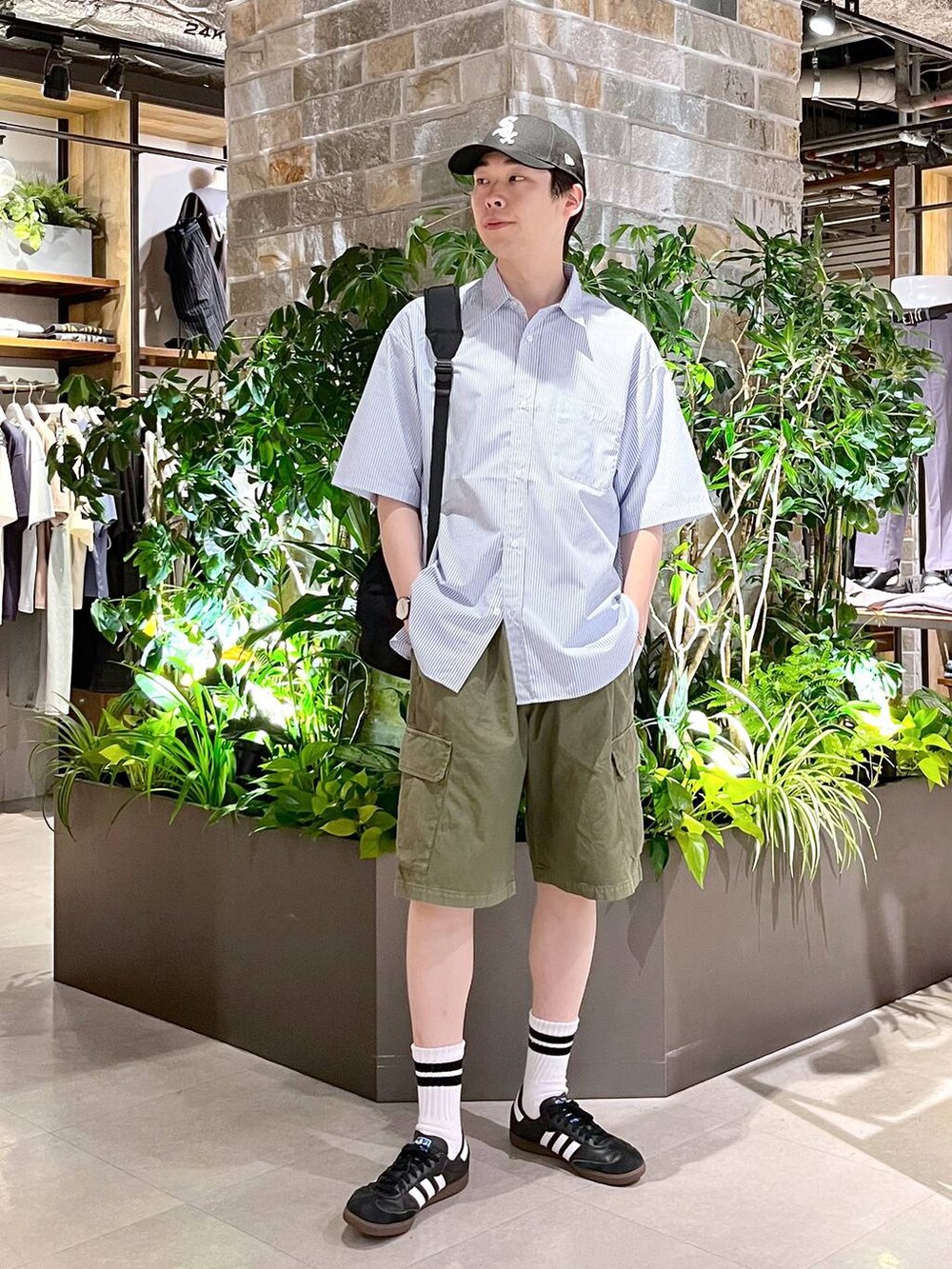 ブラック系のバックパック/リュック、ブルー系のシャツ/ブラウス、グリーン系のカーゴパンツを着用したメンズの夏コーディネートの2枚目の写真