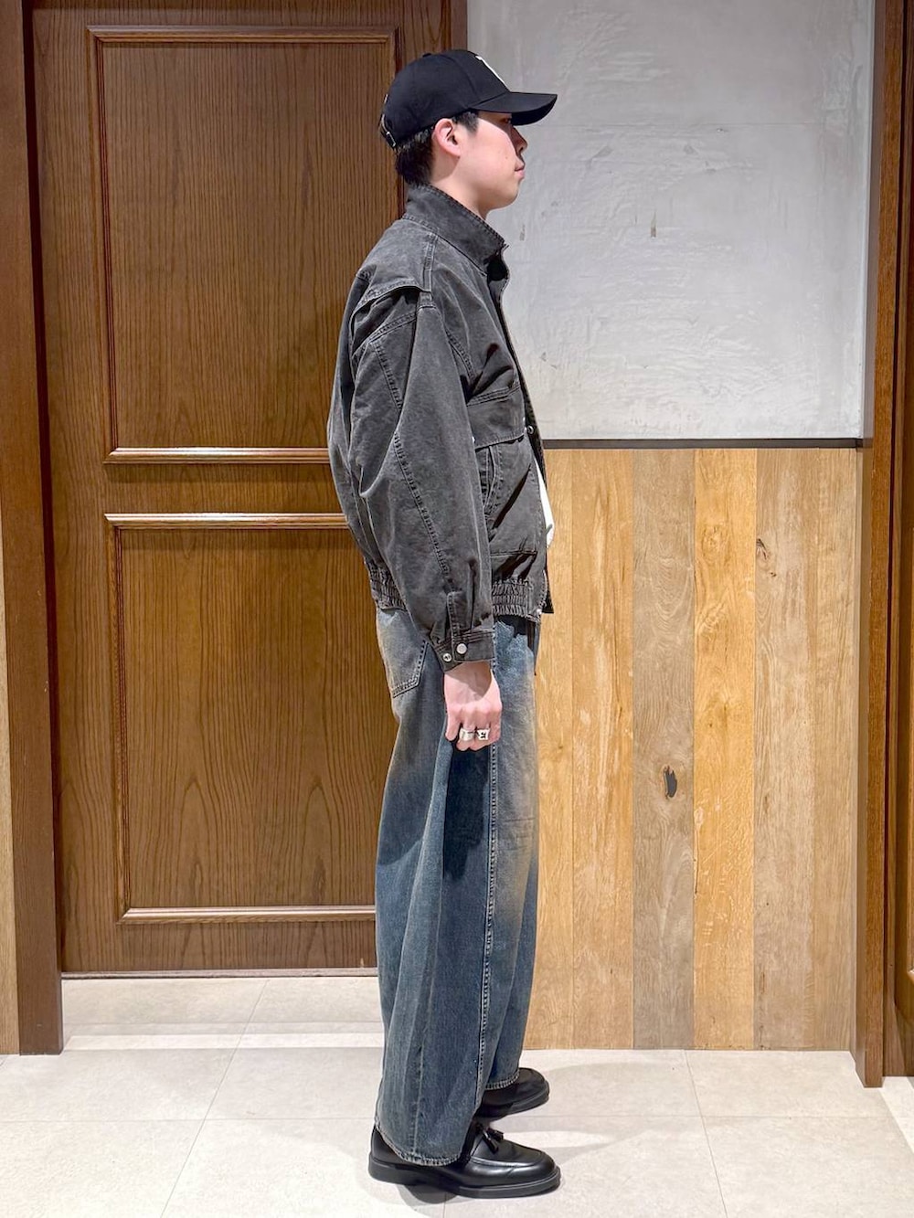 グレー系のスウェット、グレー系のブルゾン、ブルー系のデニムパンツを着用したメンズの春コーディネートの5枚目の写真