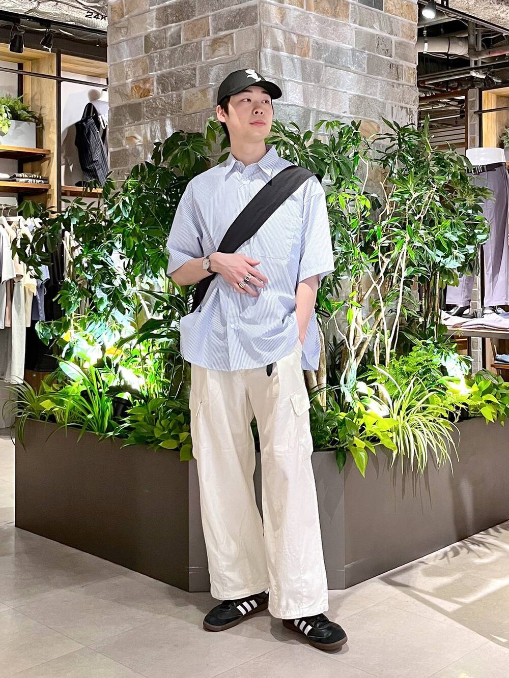 ホワイト系のカーゴパンツ、ブルー系のシャツ/ブラウス、ブラック系のショルダーバッグを着用したメンズの夏コーディネートの2枚目の写真