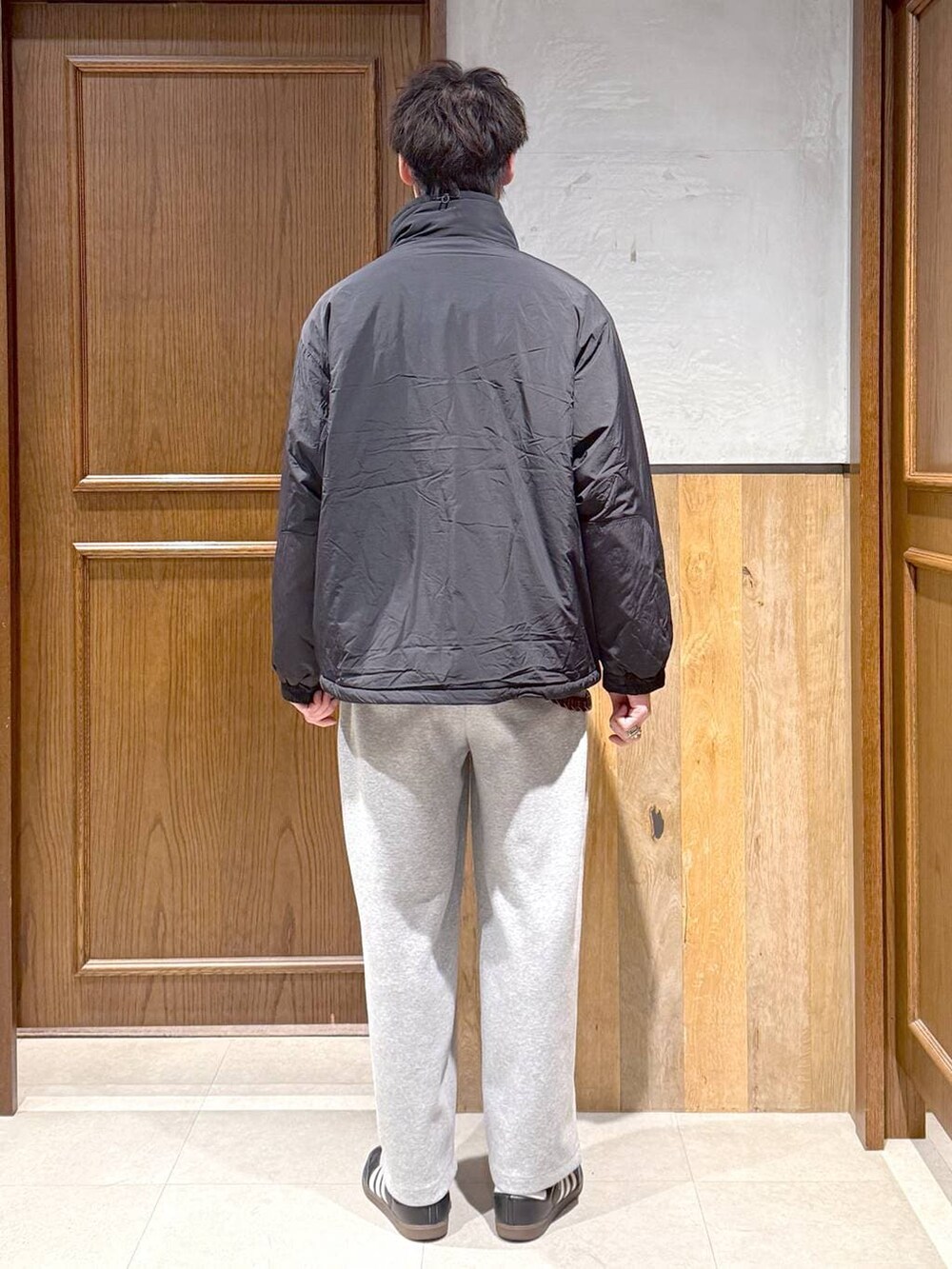 ブラック系のダウンジャケット/コート、ブルー系のニット/セーター、グレー系のスウェットパンツを着用したメンズの冬コーディネートの5枚目の写真