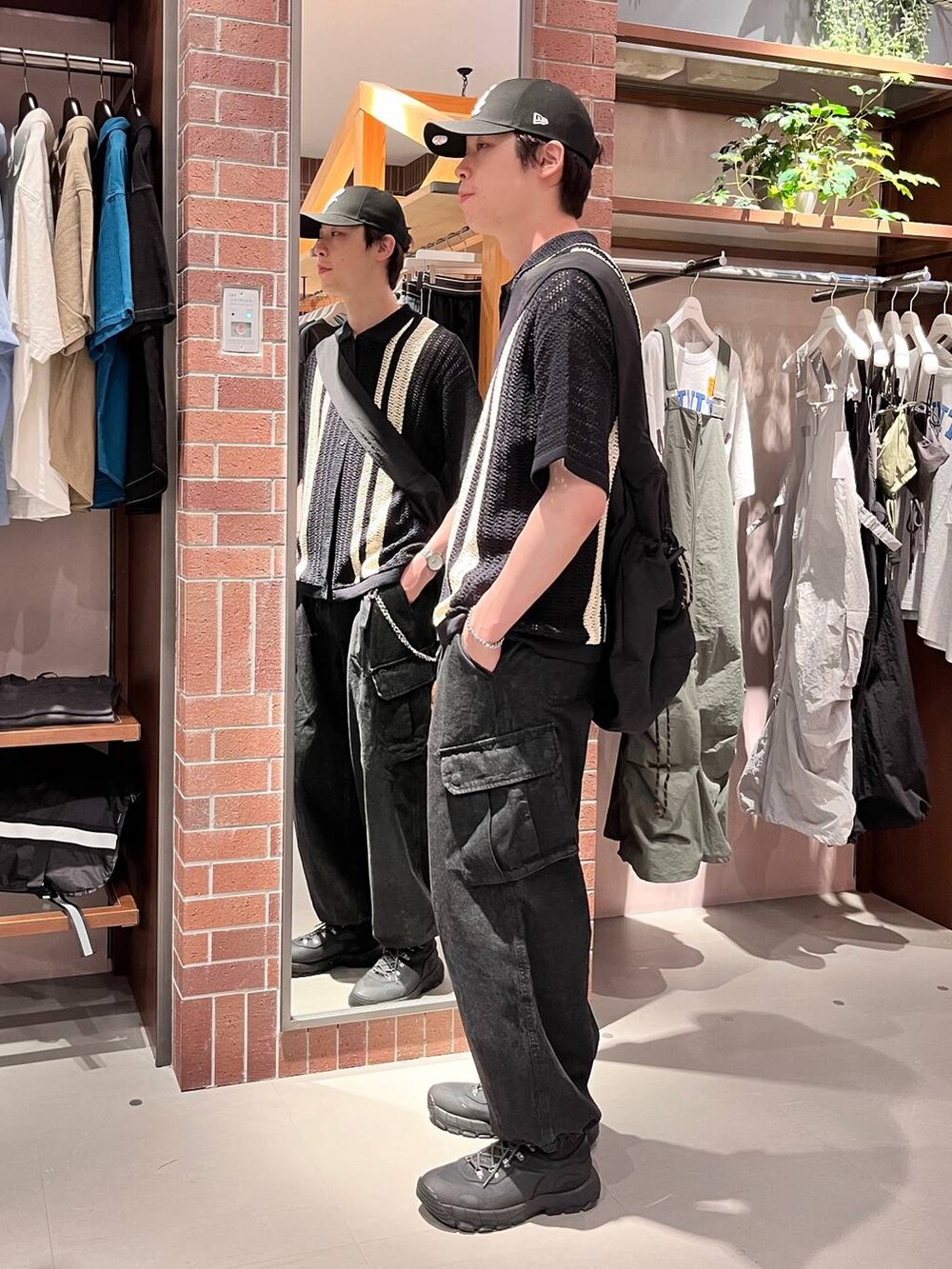 グレー系のデニムパンツ、ブラック系のショルダーバッグ、ブラック系のニット/セーターを着用したメンズの夏コーディネートの5枚目の写真