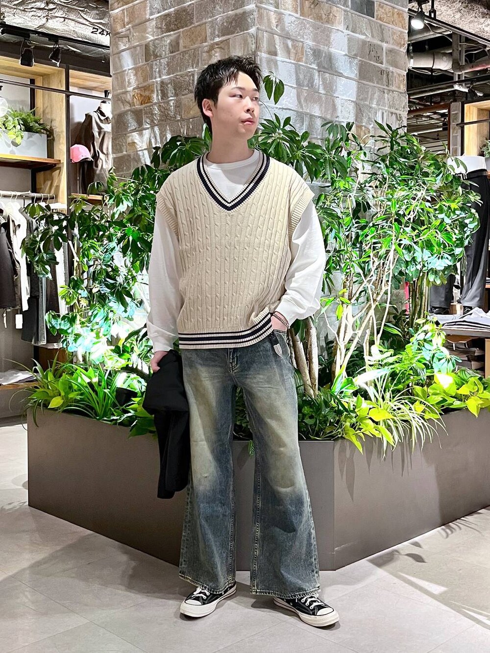ブラック系のテーラードジャケット、ブルー系のデニムパンツ、ホワイト系のニット/セーターを着用したメンズの春コーディネートの2枚目の写真