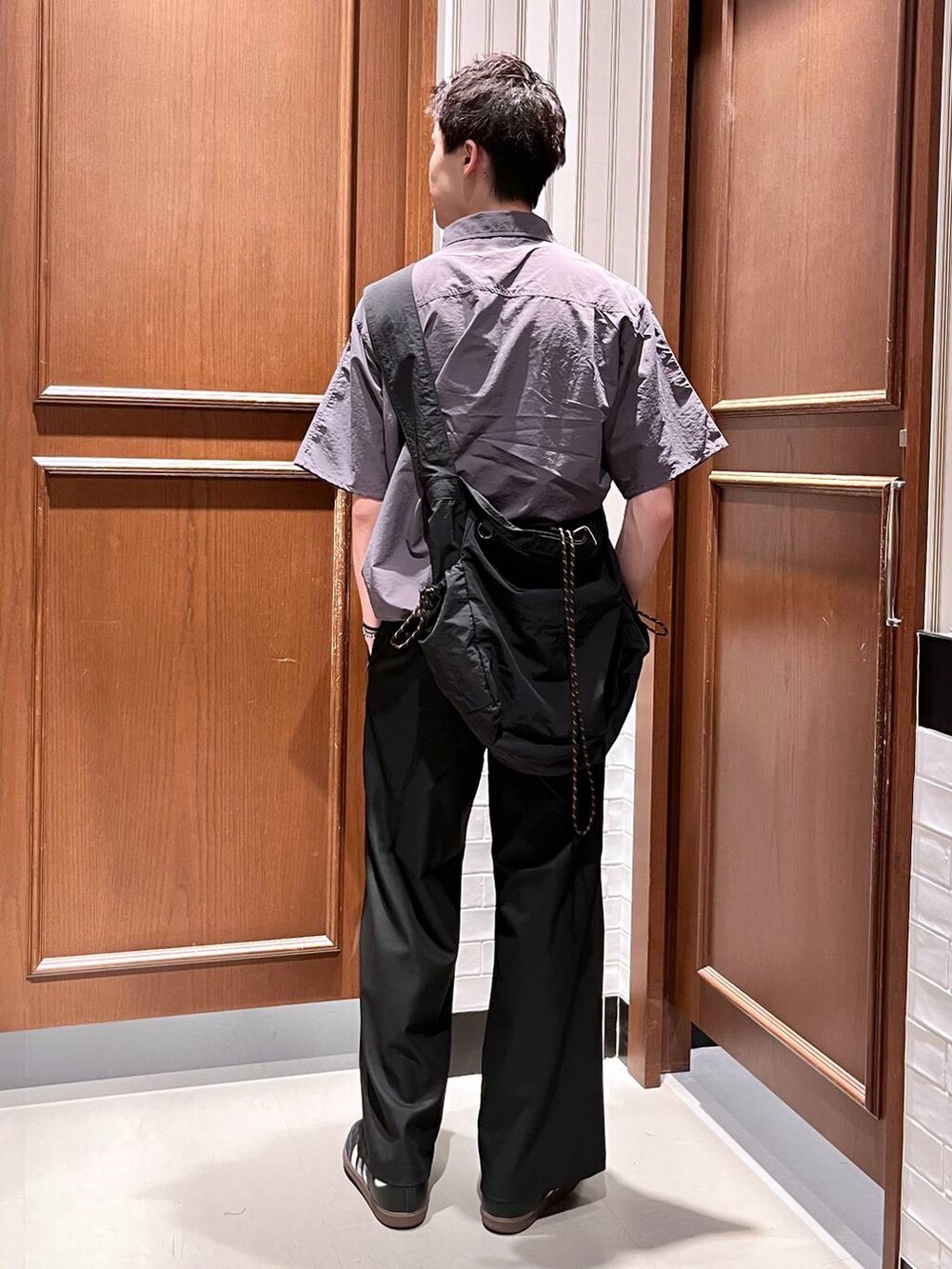 ブラック系のスラックス、ブラック系のショルダーバッグを着用したメンズの夏コーディネートの4枚目の写真