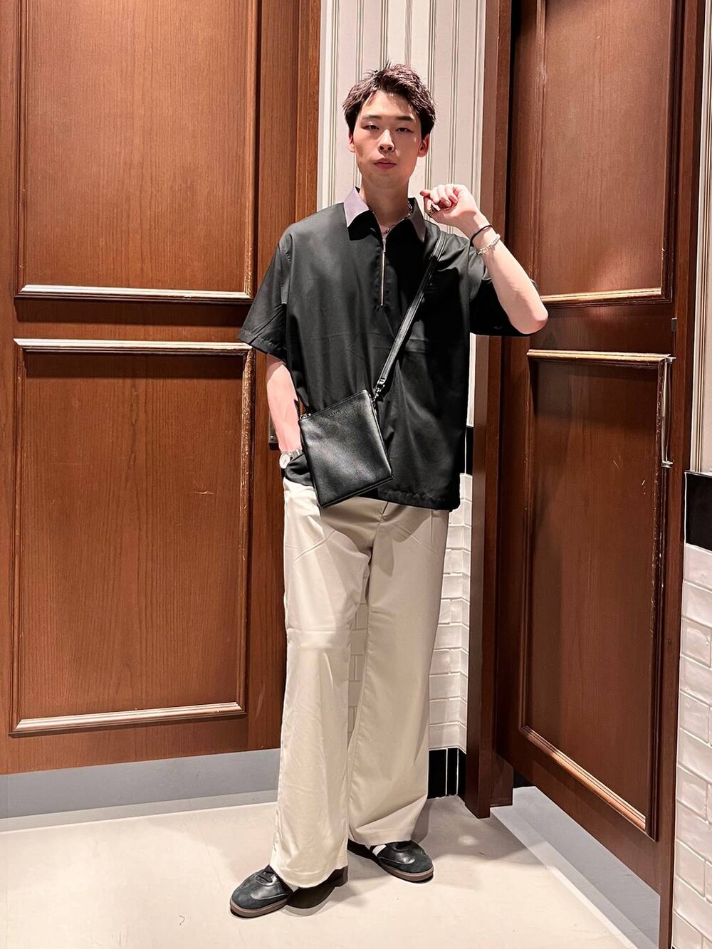 ホワイト系のスラックス、ブラック系のシャツ/ブラウス、ブラック系のショルダーバッグを着用したメンズの夏コーディネートの6枚目の写真