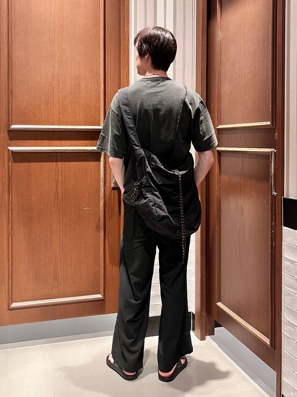 ブラック系のサンダル、ブラック系のショルダーバッグ、ブラック系のスラックスを着用したメンズの夏コーディネートの4枚目の写真