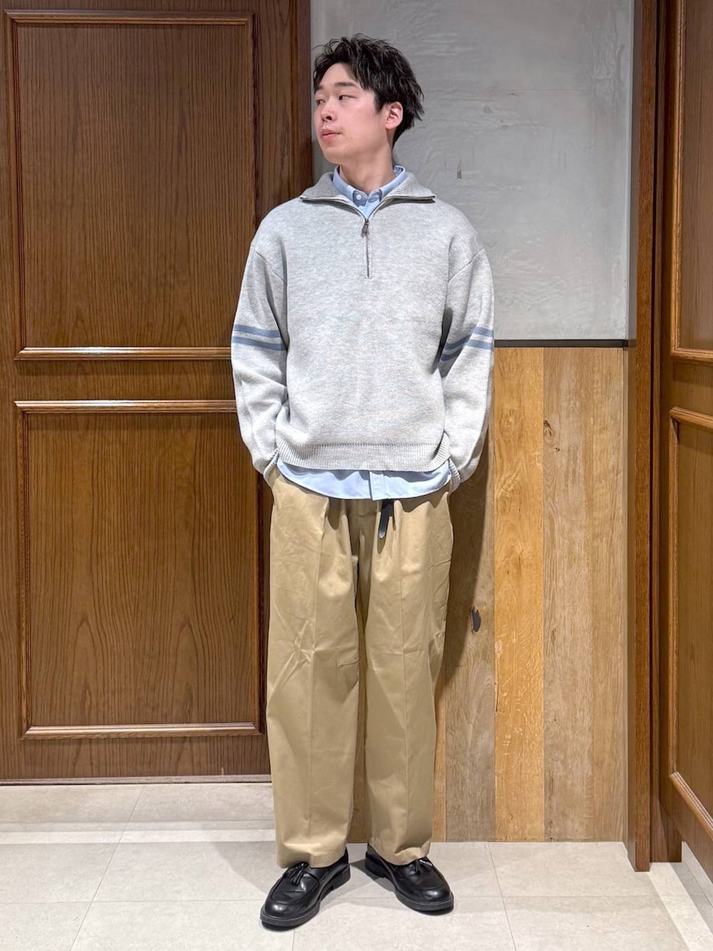 ブルー系のシャツ/ブラウス、ベージュ系のチノパンツ、グレー系のニット/セーターを着用したメンズの冬コーディネートの2枚目の写真