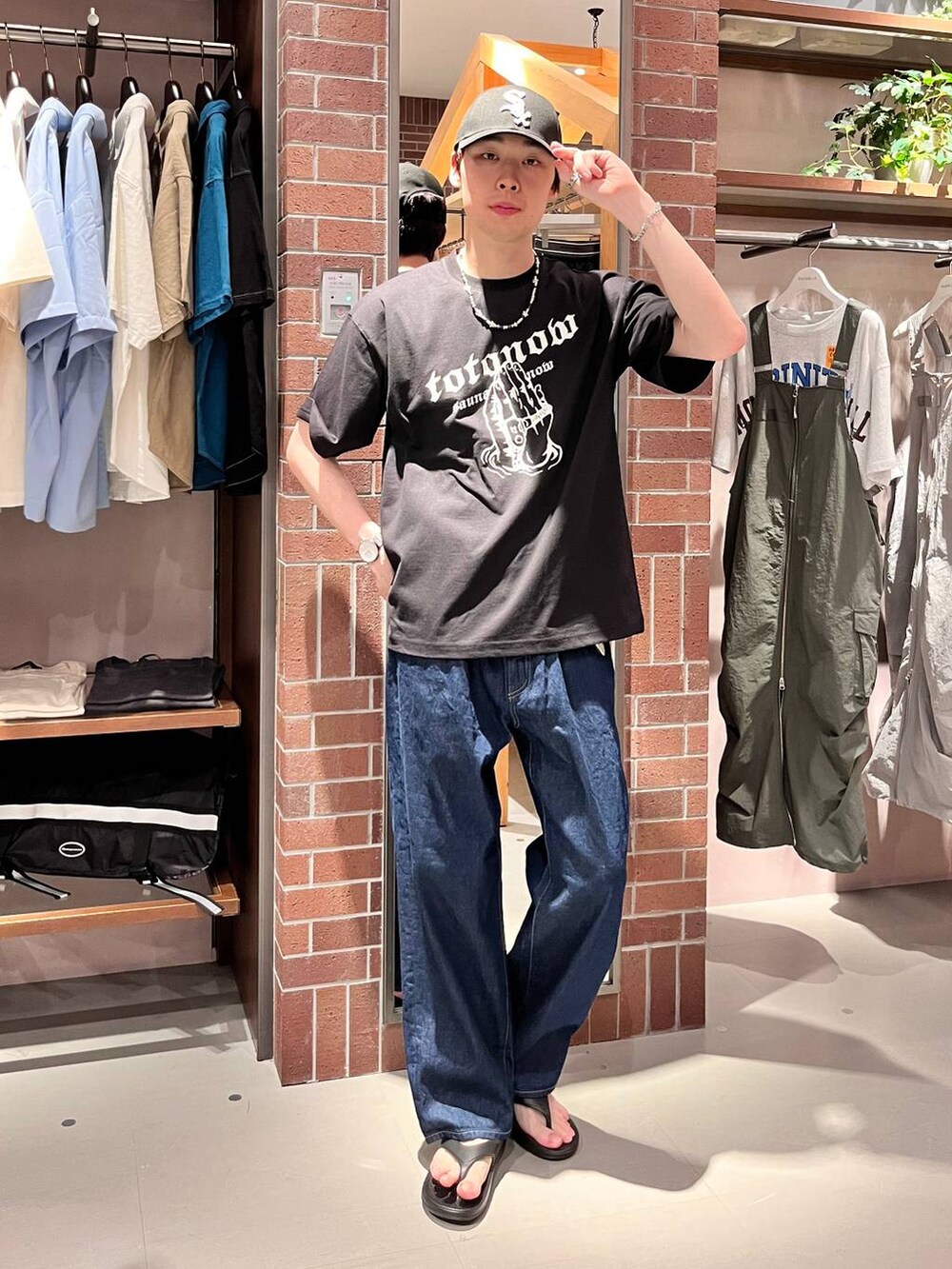 ブルー系のデニムパンツ、ブラック系のTシャツ/カットソー、パープル系のネックレスを着用したメンズの夏コーディネートの2枚目の写真