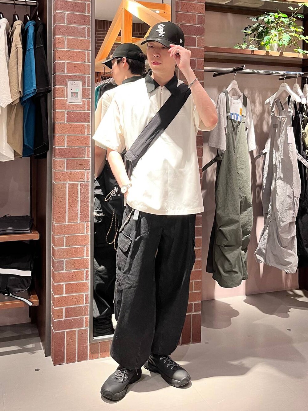 グレー系のデニムパンツ、ブラック系のショルダーバッグ、ホワイト系のシャツ/ブラウスを着用したメンズの夏コーディネートの2枚目の写真