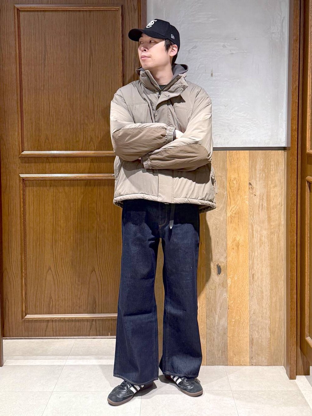 ブルー系のデニムパンツ、ブラウン系のダウンジャケット/コート、グレー系のニット/セーターを着用したメンズの冬コーディネートの6枚目の写真