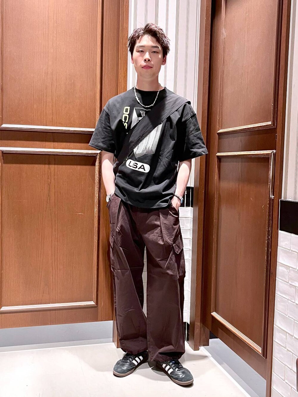 ブラウン系のカーゴパンツ、ブラック系のベスト、ブラック系のTシャツ/カットソーを着用したメンズの夏コーディネートの6枚目の写真