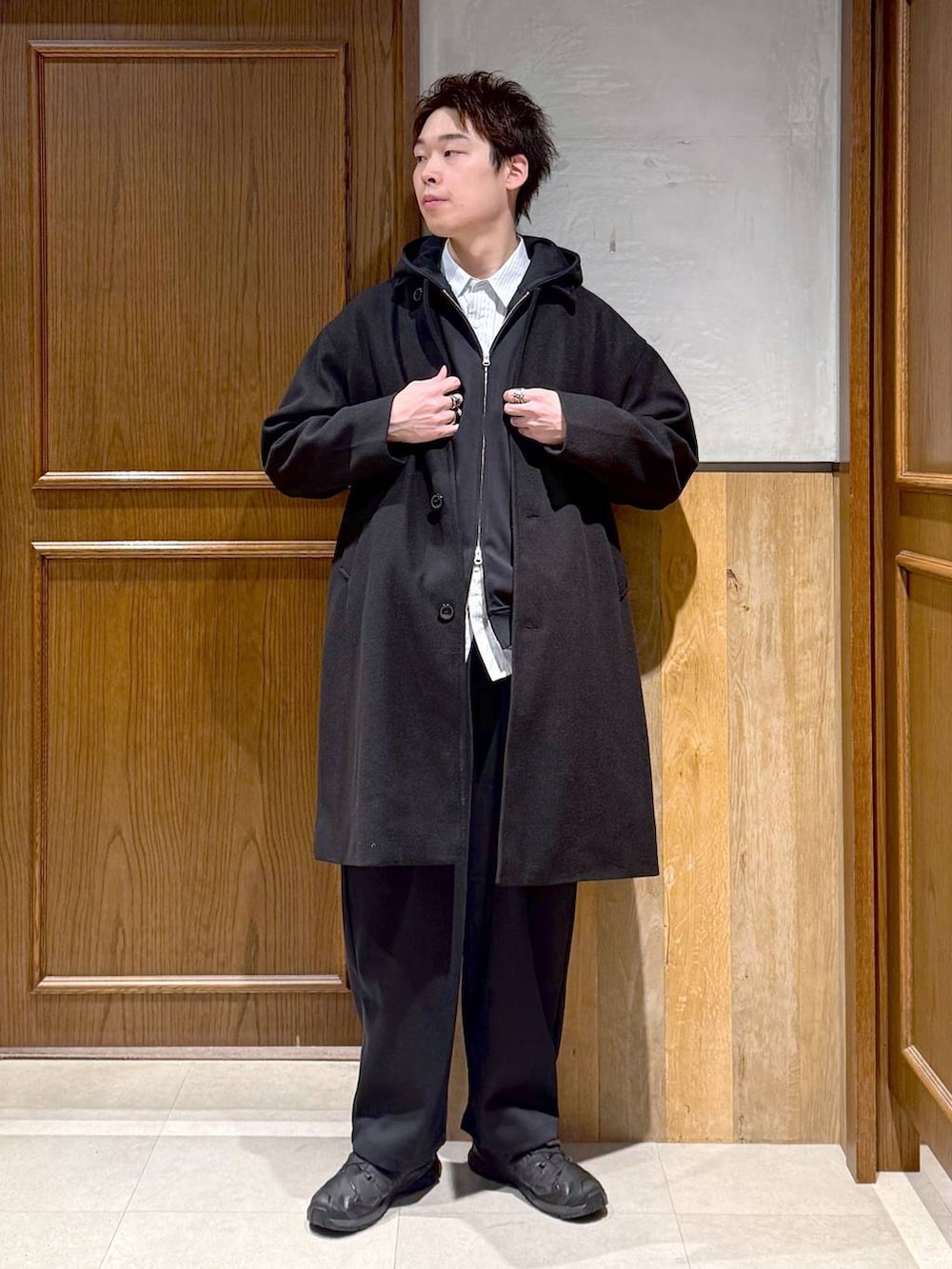 ブラック系のトレンチコート、ブルー系のシャツ/ブラウス、ブラック系のパーカーを着用したメンズの秋コーディネートの2枚目の写真