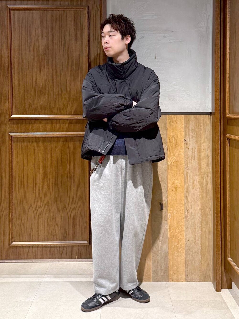 ブラック系のダウンジャケット/コート、ブルー系のニット/セーター、グレー系のスウェットパンツを着用したメンズの冬コーディネートの8枚目の写真