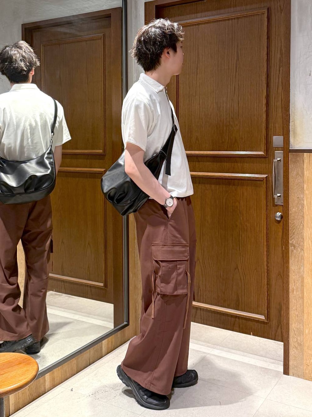 ブラック系のショルダーバッグ、イエロー系のスラックス、ホワイト系のTシャツ/カットソーを着用したメンズの春コーディネートの6枚目の写真